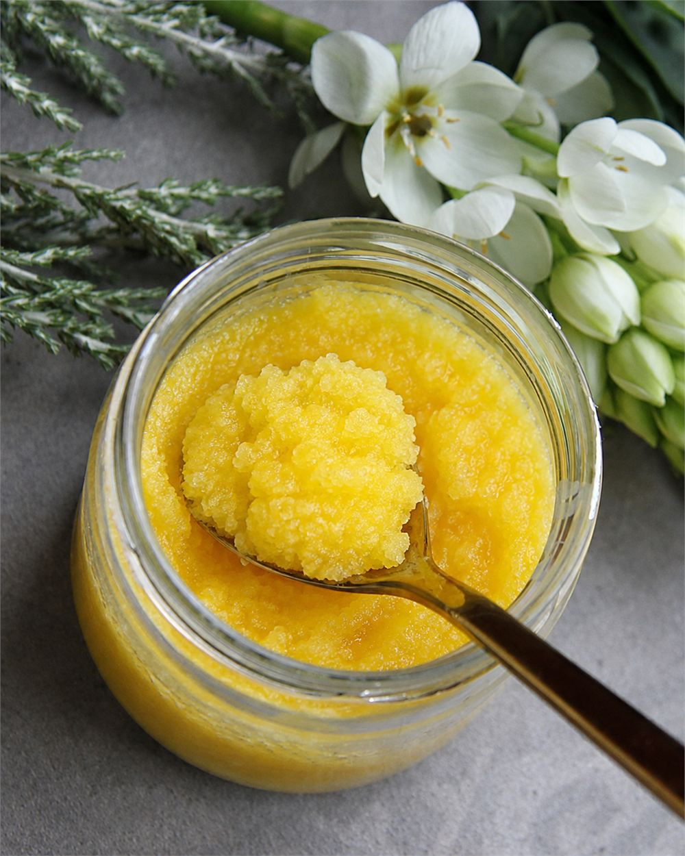 Grainy golden ghee in a glass jar